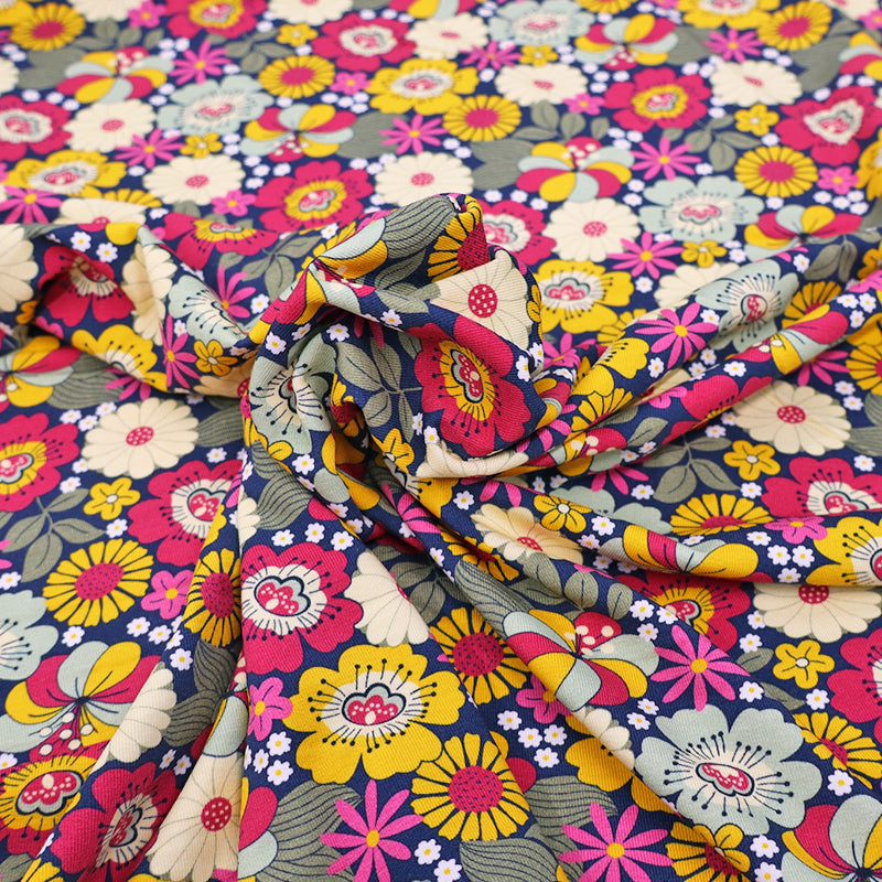 95% Cotton 5% Elastane pink floral jersey fabric by The Crafty Pie featuring a pink, red, yellow and blue floral print on dark navy blue jersey
