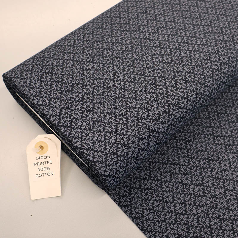 100% Cotton Geometric Fabric - Black and Grey with a small grey geometric leaf print on a solid black background.