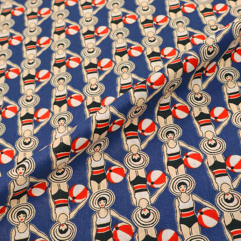 Patterned fabric with women in swimsuits and beach balls on a blue background