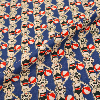 Patterned fabric with women in swimsuits and beach balls on a blue background