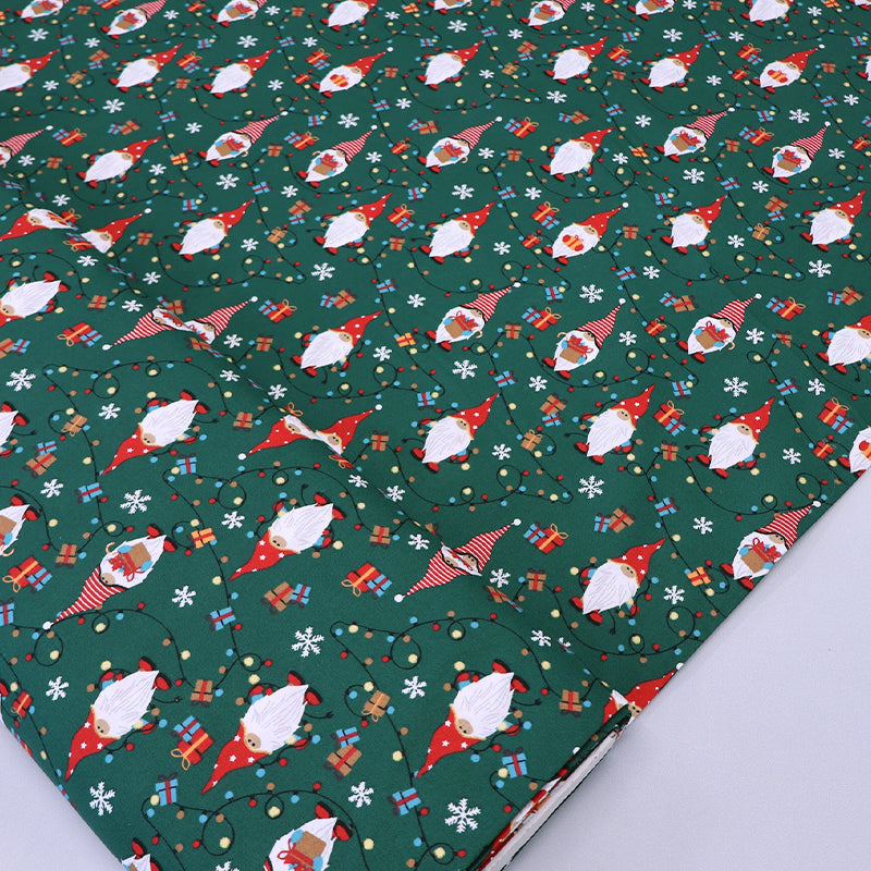 Christmas-themed 100% cotton fabric with gnomes and snowflakes on a green background
