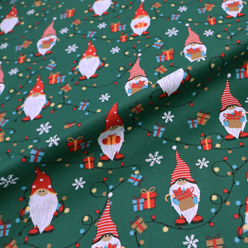 Christmas-themed 100% cotton fabric with gnomes and snowflakes on a green background