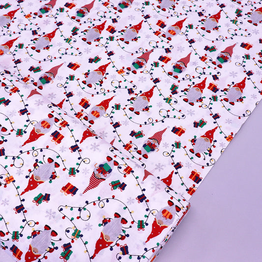 Christmas-themed white 100% cotton fabric with gnomes, presents, and lights on a white background