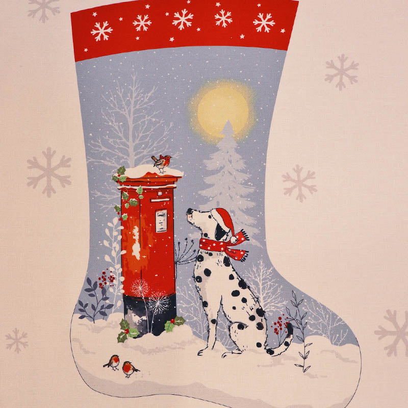 A festive Christmas stocking panel fabric with a red cuff, snowy winter scene, a red post box, a Dalmatian dog wearing a Santa hat and scarf, and a pale blue and white background with snowflake motifs.