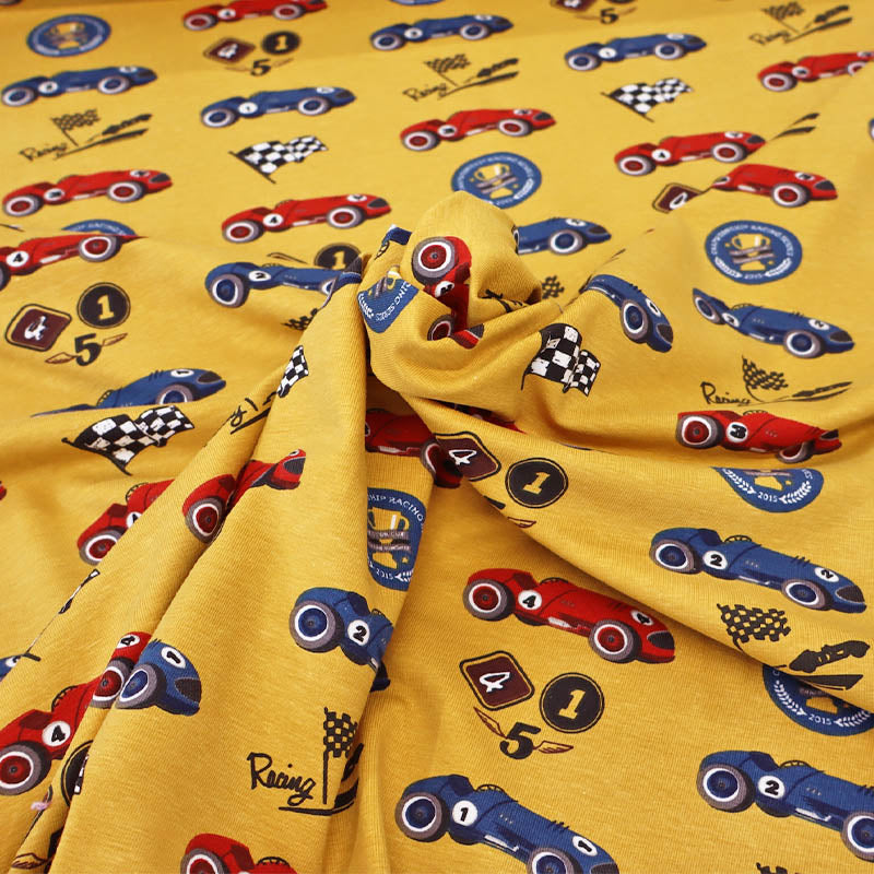 96% Cotton 4% elastane children's Jersey fabric with vintage racing cars, flags, and logos on a yellow background