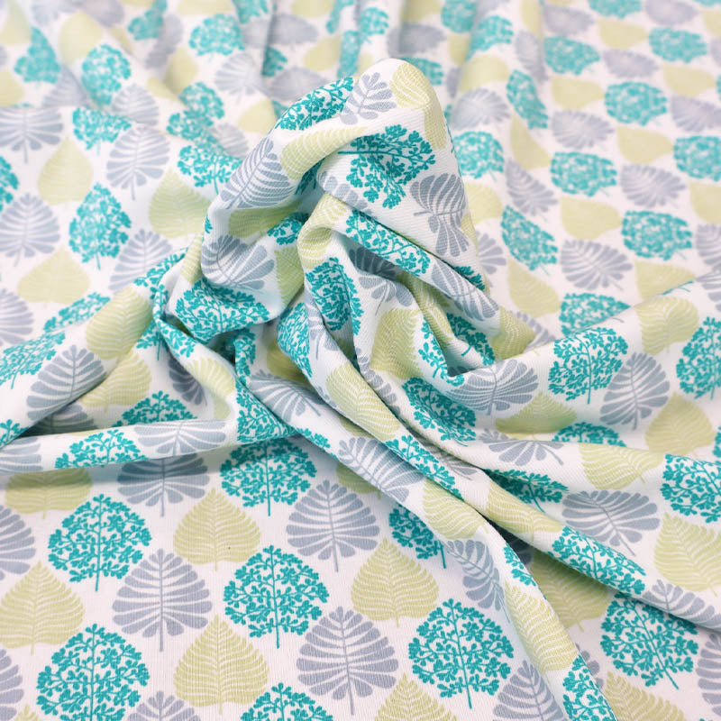 92% Cotton 8% Elastane Cotton Jersey Fabric - Green Leaves on a white background
