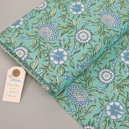  100% Cotton poplin fabric featuring a Digitally Printed pale blue and white floral and bee design with green leaves on a mint green background. 