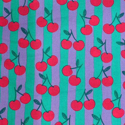 100% Cotton Poplin Fabric - Cherry Print
with red cherry print on a purple and green striped background.