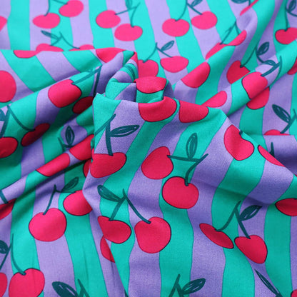 100% Cotton Poplin Fabric - Cherry Print
with red cherry print on a purple and green striped background.