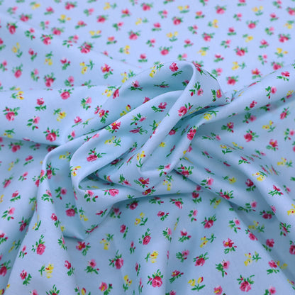 100% Cotton Ditsy Floral Poplin Fabric - small pink and yellow flowers on a pale blue background