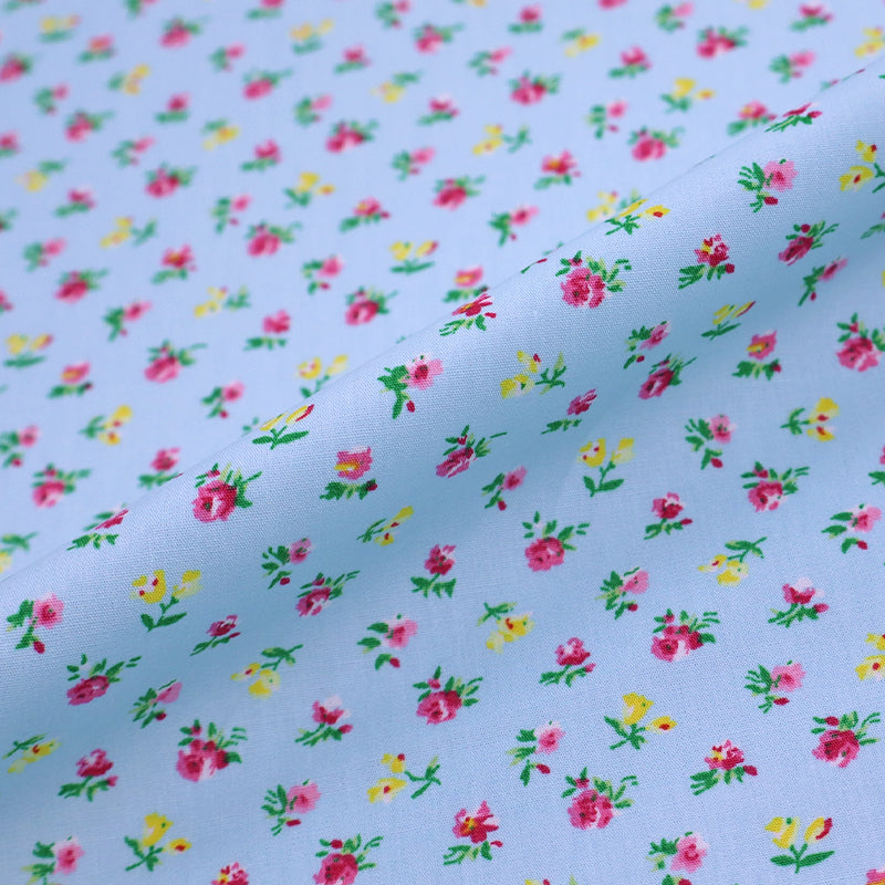 100% Cotton Ditsy Floral Poplin Fabric - small pink and yellow flowers on a pale blue background