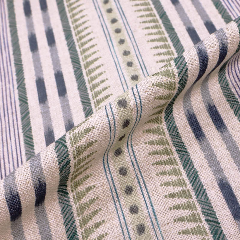  linen blend furnishing fabric featuring an unusual stripe type print in soft green and purple on a cream natural coloured background. 