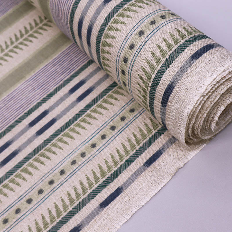  linen blend furnishing fabric featuring an unusual stripe type print in soft green and purple on a cream natural coloured background. 