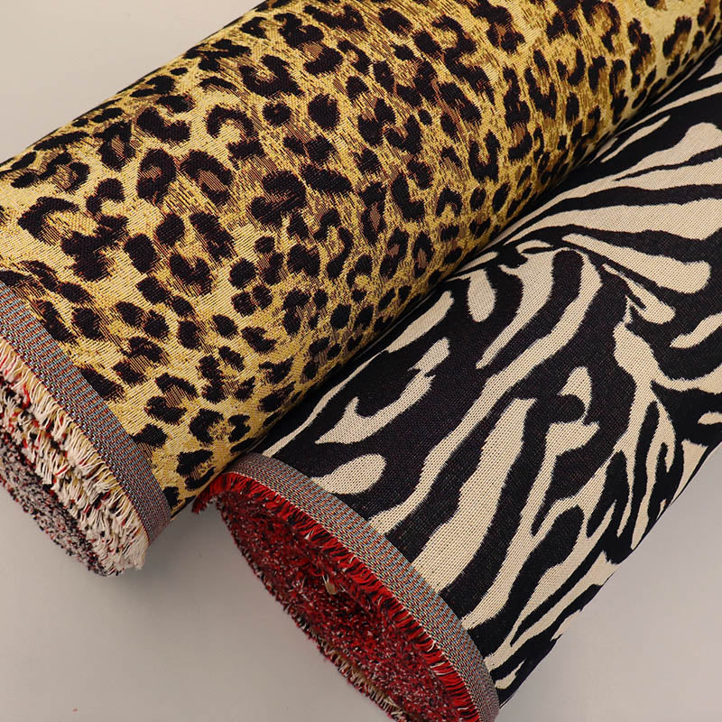 Two rolls of tapestry fabric with leopard print and zebra pattern 