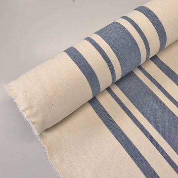 100%  Indian Cotton Denim Blue Big Striped Fabric featuring denim blue stripes of varying widths in the centre of a neutral cream colour base. 