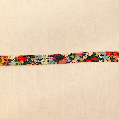 100% Cotton Liberty Fabric Bias Binding in Thorpe C featuring a vibrant floral print in coral, yellow, blue and green on a dark navy background