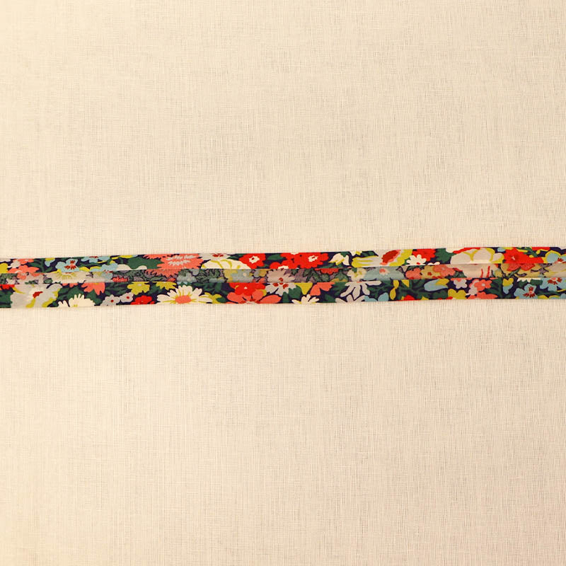 100% Cotton Liberty Fabric Bias Binding in Thorpe C featuring a vibrant floral print in coral, yellow, blue and green on a dark navy background