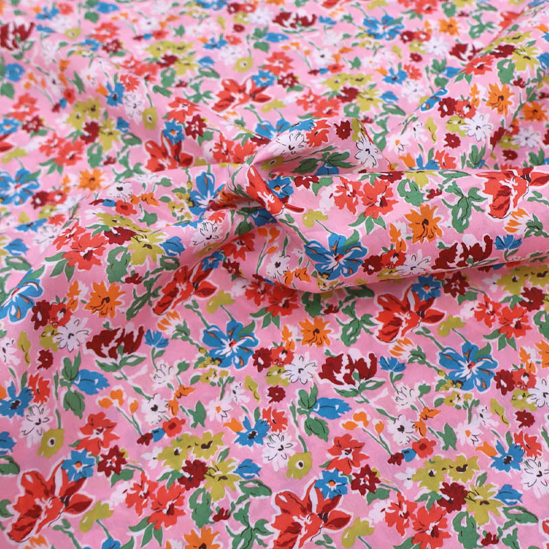 100% Cotton Liberty Cotton Lawn Fabric - Pink Floral featuring a pretty pink, orange, red and blue floral print on a pale pink background.