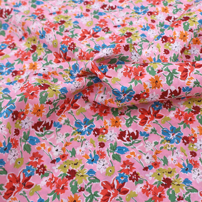 100% Cotton Liberty Cotton Lawn Fabric - Pink Floral featuring a pretty pink, orange, red and blue floral print on a pale pink background.