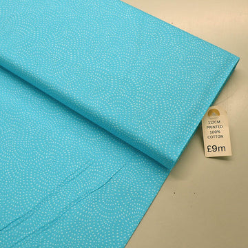 100% Cotton Turquoise Blender Fabric with a subtle print of white spots in a spiral on a turquoise blue background.