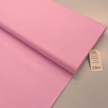 100% Cotton Pink Blender Fabric featuring a subtle print of white spots in a spiral on a pink background.