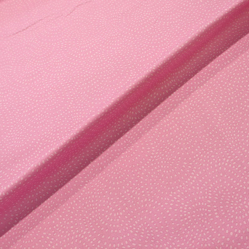 100% Cotton Pink Blender Fabric featuring a subtle print of white spots in a spiral on a pink background.