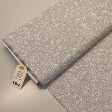 100% Cotton Pale Grey Blender Fabric featuring a subtle print of white spots in a spiral on a pale grey background.