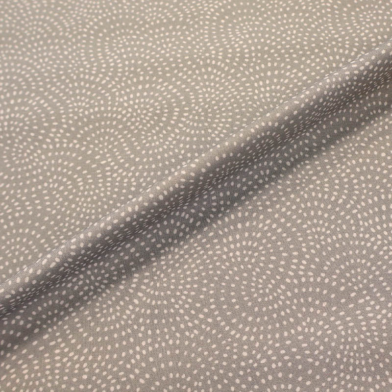 100% Cotton Pale Grey Blender Fabric featuring a subtle print of white spots in a spiral on a pale grey background.