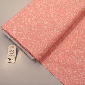 100% Cotton Pale Pink Blender Fabric featuring a subtle print of white spots in a spiral on a pale pink background.