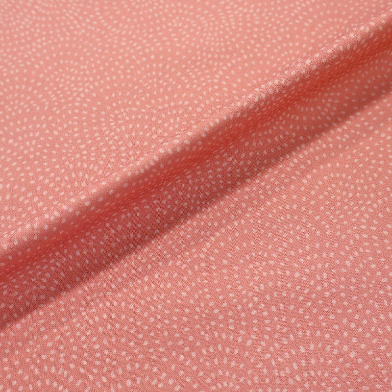 100% Cotton Pale Pink Blender Fabric featuring a subtle print of white spots in a spiral on a pale pink background.
