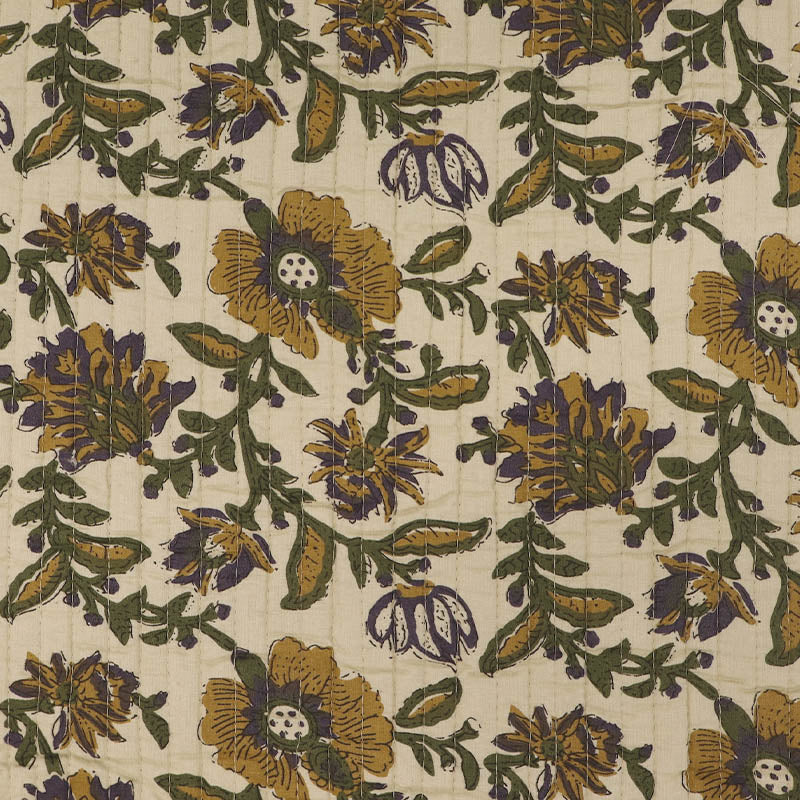 Quilted 100% Indian cotton fabric with a floral design in yellow, green and purple on a cream background on one side and a fine yellow and green stripe on a cream background on the reverse