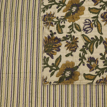 Quilted 100% Indian cotton fabric with a floral design in yellow, green and purple on a cream background on one side and a fine yellow and green stripe on a cream background on the reverse