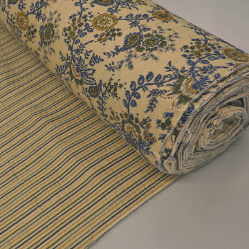Quilted 100% Indian cotton fabric with a floral design in dark blue and olive green on a cream background on one side and a fine blue and green stripe on the reverse.
