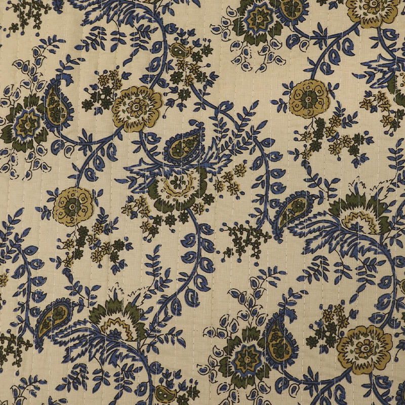 Quilted 100% Indian cotton fabric with a floral design in dark blue and olive green on a cream background 
