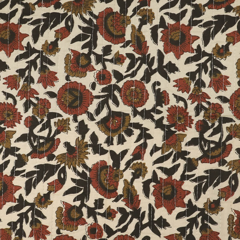 Quilted 100% Indian cotton fabric with a floral design in red, brown and black on a cream background on one side and a fine red and brown stripe on the reverse.