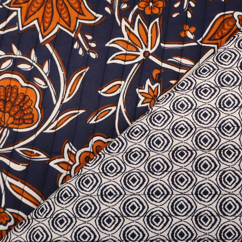 100% Cotton with Polyester Wadding QUILTED Cotton Fabric - Navy and Orange Floral with geometric navy and cream circular design on reverse