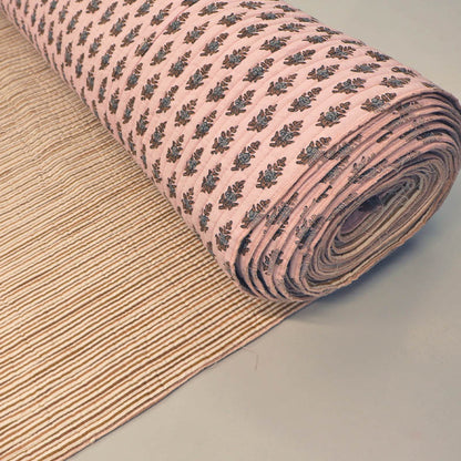 Quilted 100% Indian cotton fabric with a floral motif in brown and grey on a pale pink background on one side and a fine beige and cream stripe on the reverse.