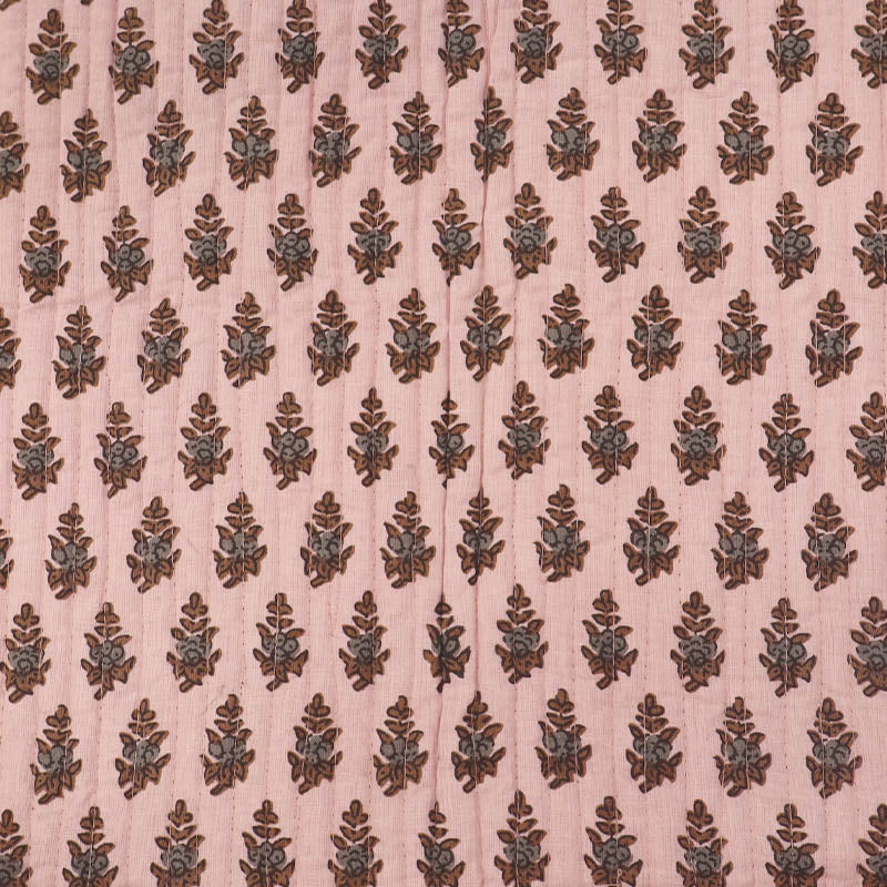 Quilted 100% Indian cotton fabric with a floral motif in brown and grey on a pale pink background 