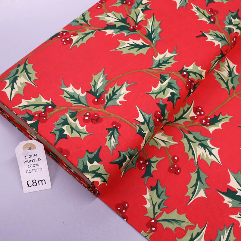 Red cotton Christmas fabric with green holly and berry print