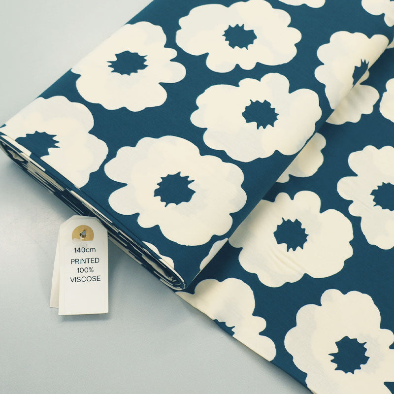 100% Viscose Floral Viscose Fabric featuring a bold modern floral in cream on a petrol blue-green background