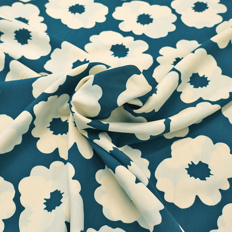 100% Viscose Floral Viscose Fabric featuring a bold modern floral in cream on a petrol blue-green background