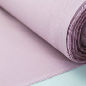 A rolled up piece of heather pink brushed cotton panama weave fabric.